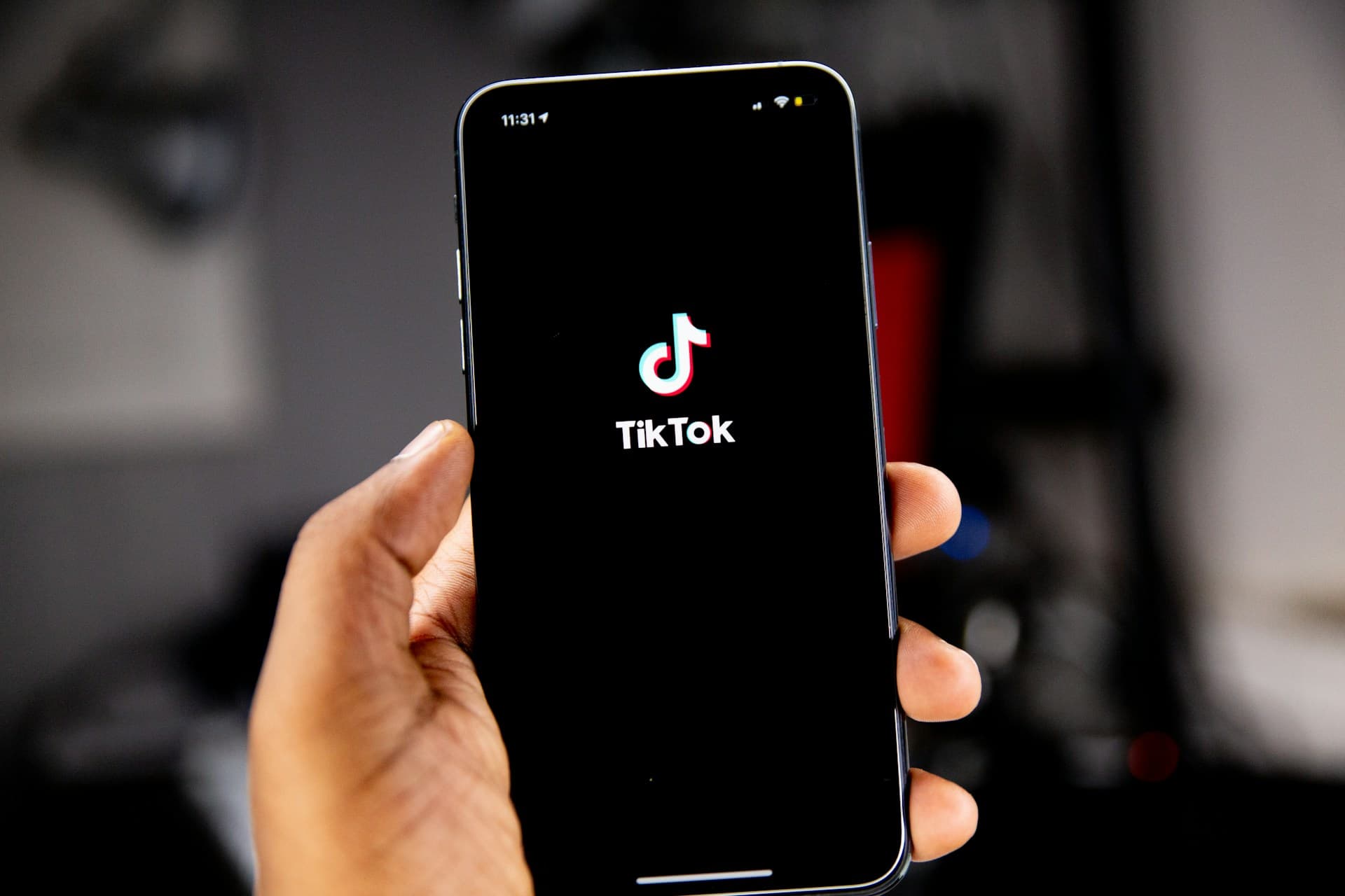 Hand hält ein Smartphone mit geöffneter TikTok-App – Symbolfoto